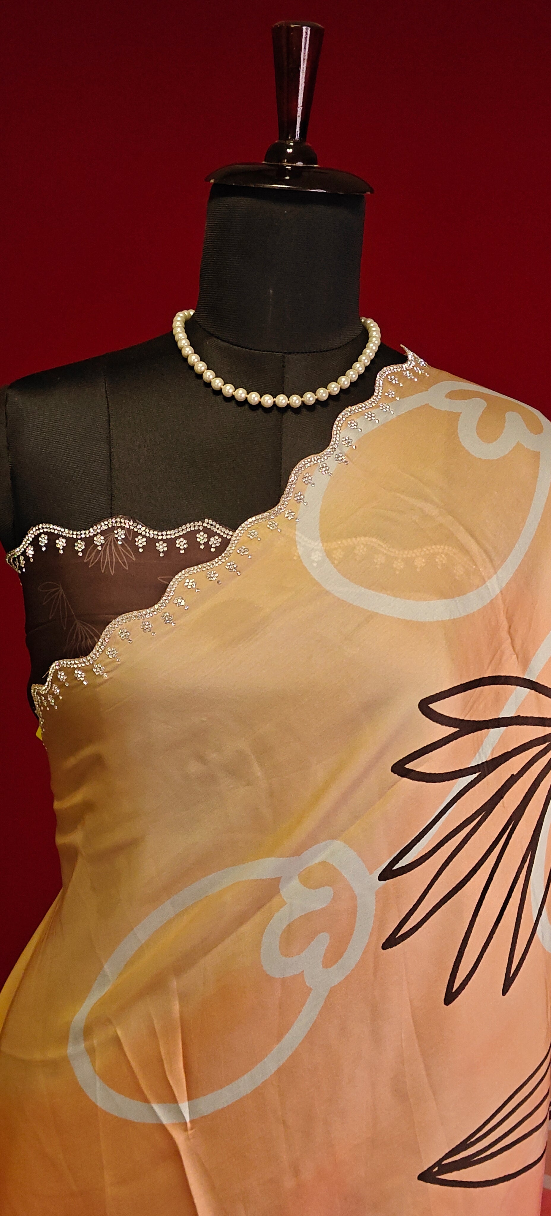 Multicolour satin georgette saree with abstract floral print and silver scalloped border on a mannequin showcasing the blouse piece with a red background.