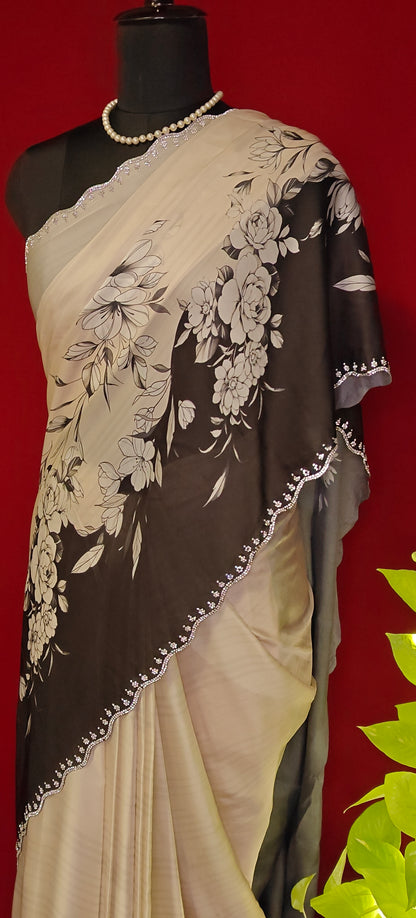 Black and white satin saree with abstract floral print and white pallu, styled on mannequin with a flower vase  against red background.