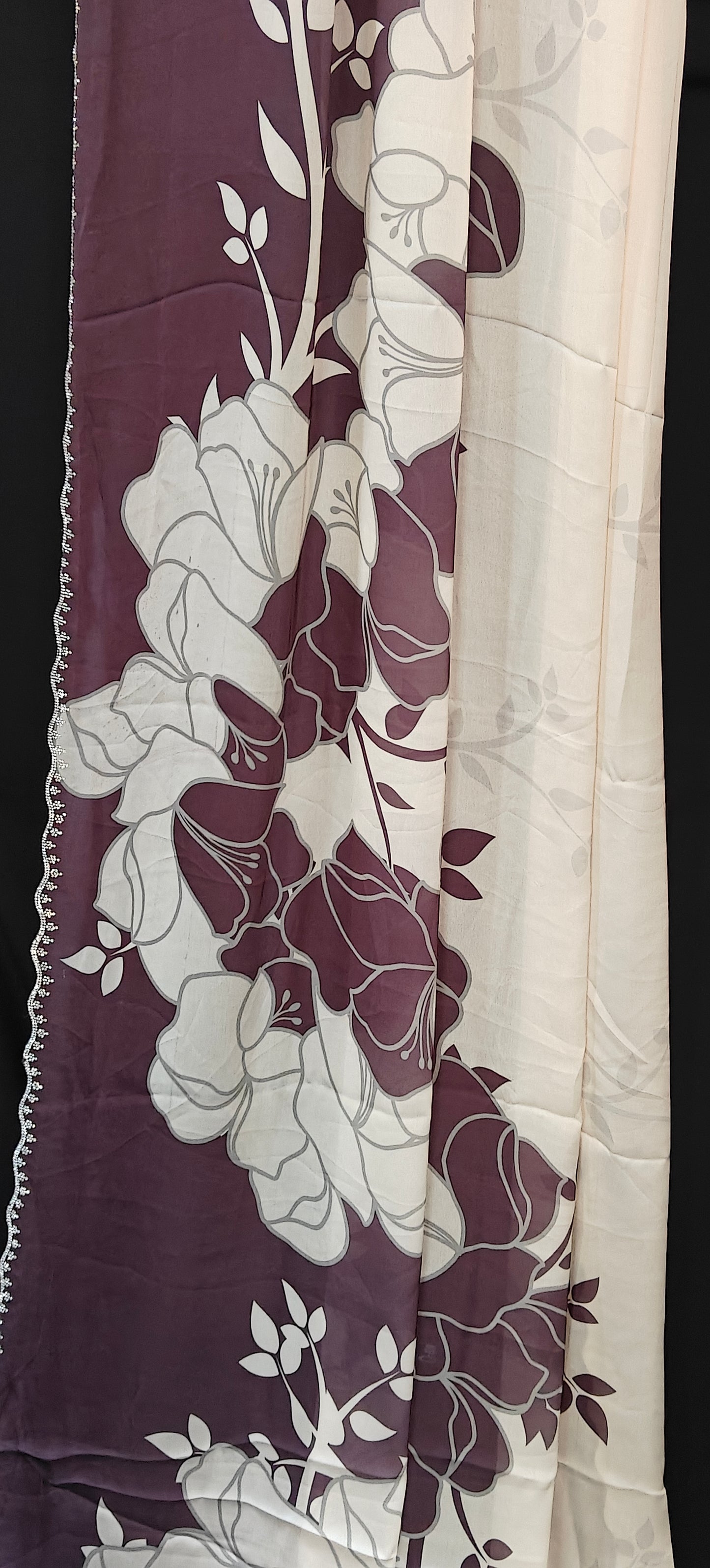 Wine red satin saree with large floral patterns and scalloped border, stylish festive saree with glossy drape.