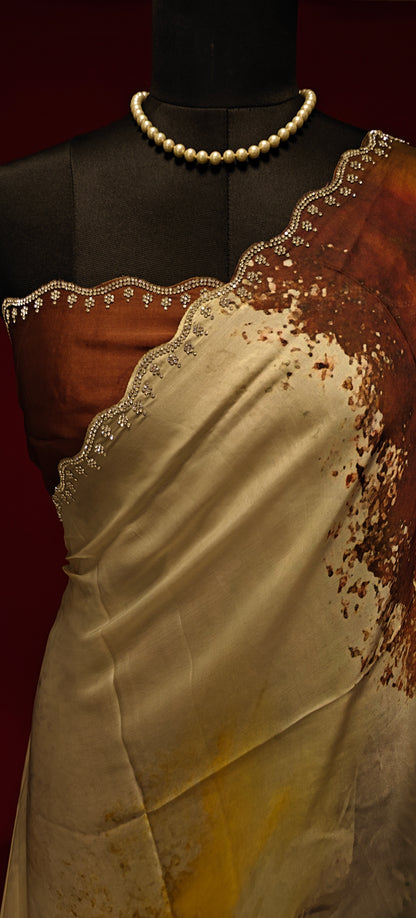 White satin georgette saree with abstract brown brushstroke print and scalloped border on a mannequin showcasing the blouse piece with a red background.