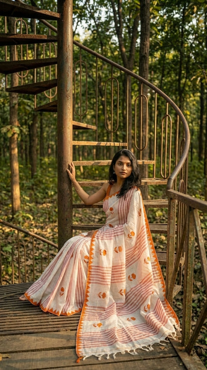 Woman in a white-cotton-saree-orange-applique, sitting on a spiral staircase in a forest.